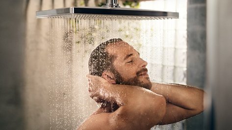 Ein Männerkopf unter einer laufenden Dusche