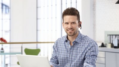 Ein Bueromann mit einem Headset